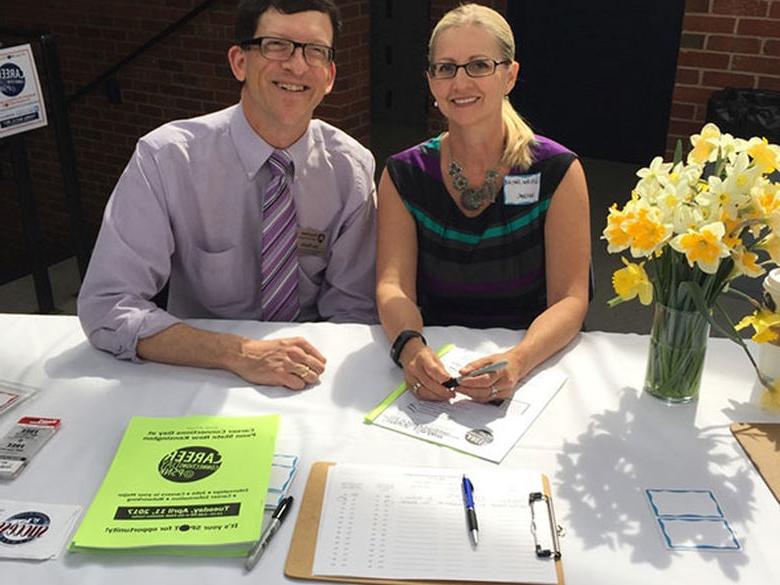 Two staff sitting at an event registration table